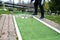 Golfer hits the ball on a mini golf course