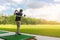 Golfer hitting golf shot with club on course at morning time