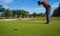 Golfer hitting golf shot with club on course vintage color tone, Man playing golf on a golf course in the sun