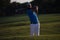 Golfer hitting a sand bunker shot on sunset