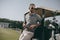 Golfer holding golf ball and looking away while leaning on golf cart