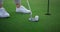 Golfer legs hitting ball on green golf course. Sport player teeing score outside