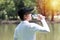 Golfer man drinking fresh water with bottle while thirsty and tired. Young men wearing black hat amid sunny hot weather holding