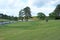 Golfer playing on a beautifully landscaped golf course with green grass, trees and blue sky background