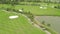 Golfer playing on green golf course top view from flying drone. Aerial view people on green field in golf club, car and