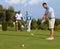 Golfer putting ball on green