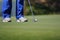 Golfer putting, selective focus on golf ball