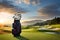 A golfer\\\'s bag of clubs set against a backdrop of rolling hills and a picturesque golf course fairway