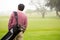 Golfer walking and holding his golf bags