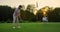 Golfers team hitting ball on sunset field course. Two players missing golf shot.