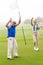 Golfing couple cheering on the putting green