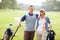 Golfing couple. Portrait of couple standing on grass with golf kit and smiling.