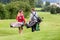 Golfing couple walking and chatting on golf course