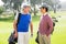 Golfing friends smiling and holding clubs