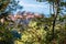 Goli Vrh - Selective close up view on lush green tree branches with panorama on the island of Sveti Stefan,
