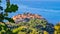 Goli Vrh - Selective close up view on lush green tree branches with panorama on the island of Sveti Stefan,