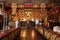 Gompa of one of the Buddhist monasteries with gilded Buddha on the altar, and ritual musical instruments on foreground