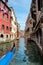 Gondola on canal between old houses at Venezia