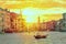 Gondola with gondolier near Rialto Bridge Grand Canal in Venice, Italy during sunset. Venice postcard. Tourism concept.