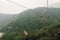 Gondola lifts moving over mountain with green trees in the area of Sun Moon Lake Ropeway in Yuchi Township, Nantou County, Taiwan