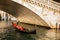 Gondola passing under the Rialto Bridge at sunset in Venice, Italy