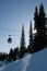Gondola at ski resort, backlit trees