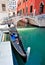 Gondola on Venice canal with bridge