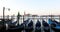 Gondolas moored and canal in Venice, boat passing in the morning, Italy