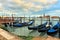 Gondolas moored in row on Grand canal in Venice.