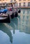 Gondolas parked on a canal in Venice, Italy showing the decorative ferro / iron at the bow of the boats and the risso