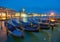 Gondolas at the St. Marks square in Venice, before a dramatic sunrise