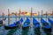 Gondole docked by wooden mooring poles in grand canal, Ethereal Venice, Italy