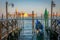 Gondole docked by wooden mooring poles in grand canal, Ethereal Venice, Italy