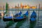 Gondole docked by wooden mooring poles in grand canal, Ethereal Venice, Italy