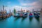 Gondole docked by wooden mooring poles in grand canal, Ethereal Venice, Italy