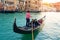 Gondolier carries tourists on gondola Grand Canal of Venice, Italy