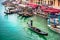 Gondolier carries tourists on gondola in Rialto, Venice, Italy. March, 11st. 2019