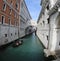 Gondolier carries tourists on the gondola under the Bridge of Si