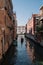 Gondolier drives a gondola on a canal in Venice, Italy