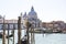 A gondolier drives a gondola with tourists on board near Santa Maria Della Salute in Venice