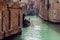 Gondolier floats on the narrow channel in Venice, Italy