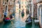 Gondolier on a gondola on canal street in Venice, Italy