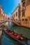 Gondolier in gondola in Venice canal