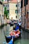 Gondolier navigating a gondola through canal