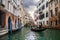 Gondolier on ornamental boat in channel water