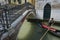 Gondolier Pushing Gondola Under Bridge in Venice, Italy