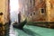 Gondolier rowing in canal with green water
