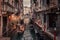 Gondolier rowing down a narrow canal in Venice, Italy