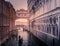 Gondolier rows down a canal towards the historic Bridge of Sighs