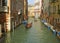 The Gondolier Sailing a Gondola on a Small Canal of Venice